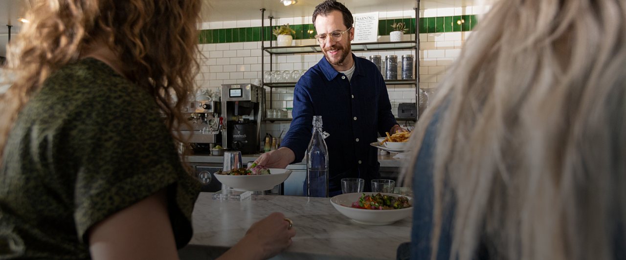 Restaurant staff serving customers at the counter